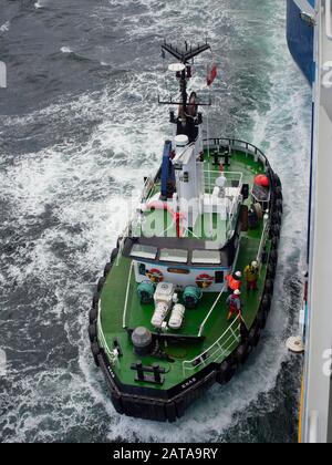 Il pilota insieme A Due Persone che assistono, sul ponte della barca pilota Lerwick che si avvicina al lato Della Scala pilota Di Una Nave in preparazione a bordo Foto Stock