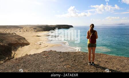 Hiker femminile che gode di vista delle spiagge di Playas de Papagayo a Lanzarote, Isole Canarie Foto Stock