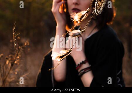 Boho portreit di donna con capelli ventosi corti. Dreamcatcher, sfondo astratto etnico. Messa a fuoco selettiva, primo piano Foto Stock