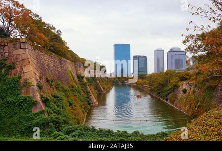 La vista lungo la superficie interna fossato del castello di Osaka con l'Osaka Business Park sullo sfondo. Osaka. Giappone Foto Stock