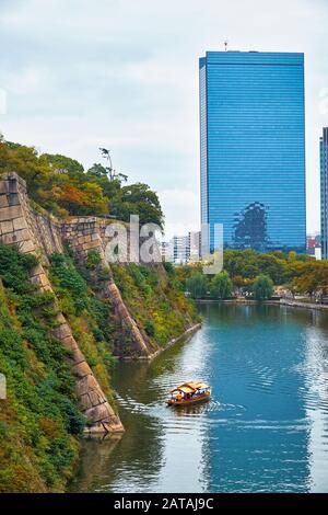 La vista lungo la superficie interna fossato del castello di Osaka con l'Osaka Business Park sullo sfondo. Osaka. Giappone Foto Stock