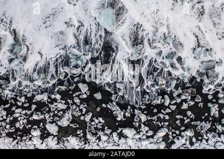 Vista aerea del ghiaccio e floes iceberg sulla spiaggia di diamante durante il tramonto. L'inizio della primavera in Islanda Foto Stock