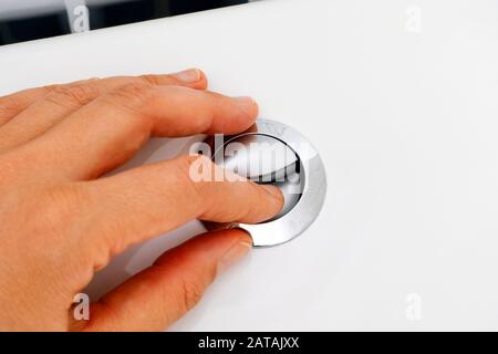 Primo piano delle mani delle donne premendo il pulsante per il lavaggio. Foto Stock