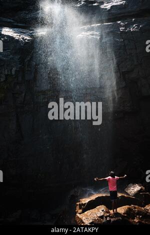 L'uomo locale si trova di fronte a una splendida cascata nella gamma Knuckles, Sri Lanka Foto Stock