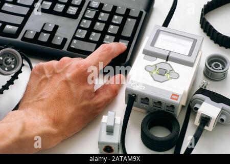 Tambov, Federazione russa - 25 dicembre 2019 Persone che codificano la tastiera LEGO MINDSTORMS EV3 blocchi robot sul computer. Foto Stock