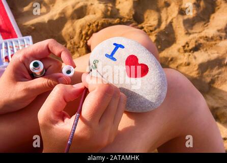 Donna sulla spiaggia è di ghiaia - mi cuore, s.. Primo piano. Foto Stock