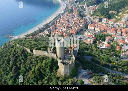 VISTA AEREA. Castello con vista sul borgo medievale di Noli. Provincia di Savona, Liguria, Italia. Foto Stock