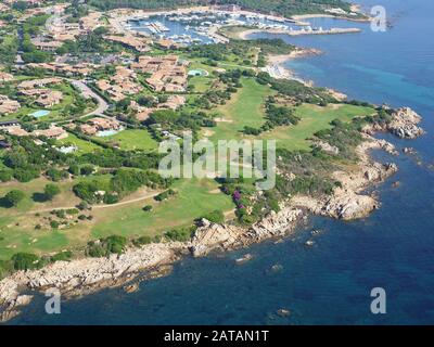 VISTA AEREA. Campo da golf in una posizione pittoresca lungo una costa rocciosa. Punta Alcia, Provincia di Sassari, Sardegna, Italia. Foto Stock