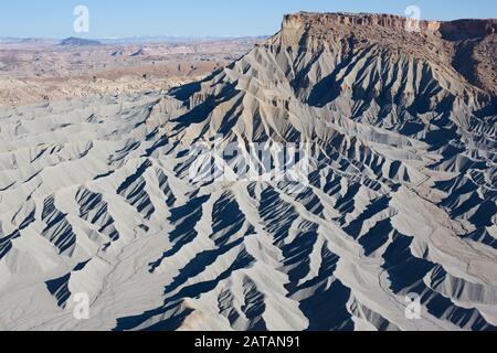 VISTA AEREA. Paesaggio di tasso grigiastro ai piedi di una mesa. Caineville, Utah, Stati Uniti. Foto Stock