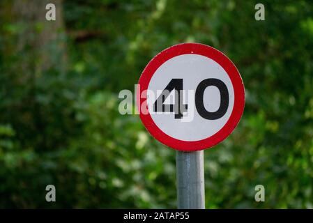 Primo piano di un cartello stradale britannico 40mph con uno sfondo verde naturale Foto Stock