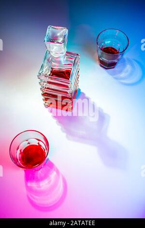 Caraffa quadrata in vetro con liquore e due bicchieri di vetro. Vista dall'alto Foto Stock