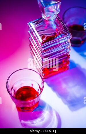 Caraffa quadrata in vetro con liquore e due bicchieri di vetro. Vista dall'alto Foto Stock