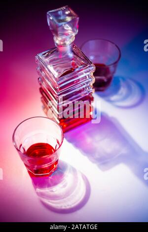 Caraffa quadrata in vetro con liquore e due bicchieri di vetro. Vista dall'alto Foto Stock