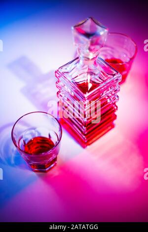 Caraffa quadrata in vetro con liquore e due bicchieri di vetro. Vista dall'alto Foto Stock