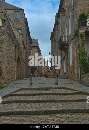 DINAN, Francia - 7 Aprile 2019 - svuotare la strada con la costruzione di pietra nella città tradizionale Foto Stock