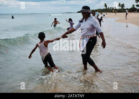 Famiglie dello Sri Lanka che godono di tempo libero su una spiaggia tropicale a Trincomalee. Foto Stock