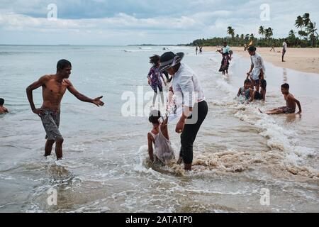 Famiglie dello Sri Lanka che godono di tempo libero su una spiaggia tropicale a Trincomalee. Foto Stock