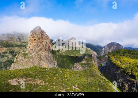 Torri di roccia vulcanica Roque de Agando con Roque de Zarcita e Roque de Ojila e strada alta, nuvole di vento commerciali, Monumento Naturale de los Roques Foto Stock