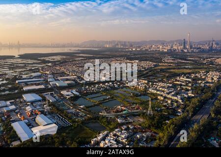 Veduta aerea dei campi verdi rurali nel confine di Hong Kong e dei lucernari in Shenzhen, Cina Foto Stock