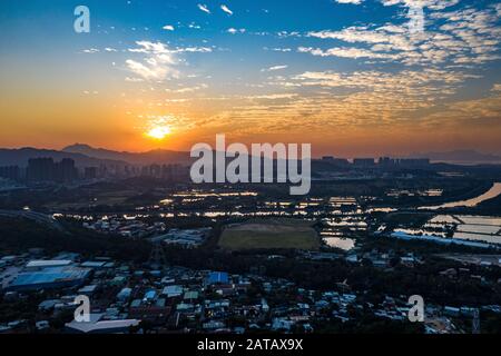 Veduta aerea dei campi verdi rurali nel confine di Hong Kong e dei lucernari in Shenzhen, Cina Foto Stock