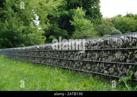 Nel parco. Una parete efficace, veloce da installare fatta di gabioni. Foto Stock