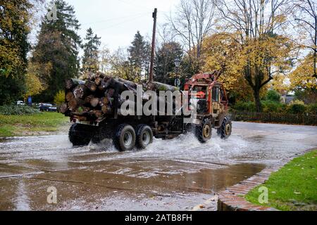 Guida di trattrice in strada allagata a Brockenhurst, Hampshire Foto Stock