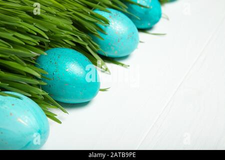 Uova di Pasqua in erba verde fresca. Su sfondo bianco Foto Stock