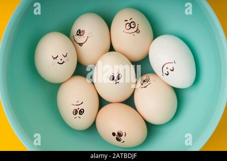 Set di uova emotive di design per la buona Pasqua in acqua menta colore fiocco su sfondo giallo. Vista dall'alto Foto Stock