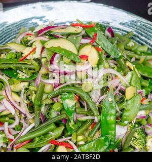 Insalata di verdure estive in ciotola di vetro, primo piano. Inquadratura quadrata. Foto Stock