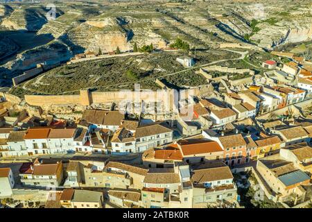 Veduta aerea della città medievale di Jorquera con le mura della città e il castello circondato dalla curva del fiume Jucar in Spagna Foto Stock