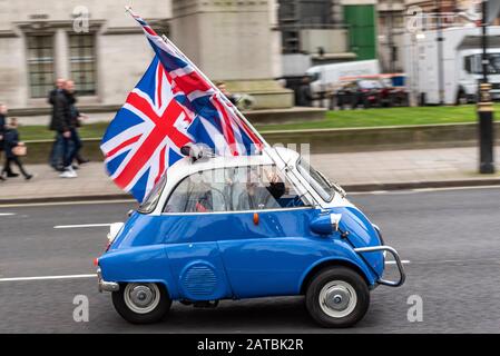 BMW Isetta microscar che guida attorno a Parliament Square il giorno della Brexit, 31 gennaio 2020, a Londra, Regno Unito, con Union Jack flags. Bollicina europea Foto Stock