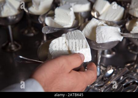 Gelato bianco in metallo nel vassoio fuoco selettivo. Tazza di gelato inossidabile che si dispone nel . Gelato in due ciotole retrò di metallo su un Foto Stock