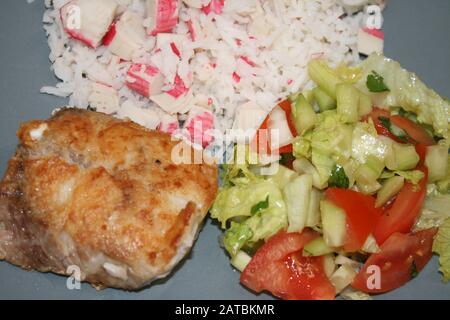 Cibo sano. Riso con granchio, insalata e bistecca con pesce persico fritto sul nilo Foto Stock