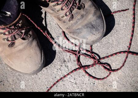 Coppia di scarpe da trekking ad alta quota preferite, usurate e sporche, coperte di fango e lacci, vista dall'alto. Concetto di viaggio, escursioni, passeggiate in montagna Foto Stock