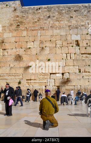 Gerusalemme, Israele - 19 febbraio 2017: Un soldato armato non identificato si inchina e prega davanti al Muro Occidentale, il luogo più sacro per l'ebraismo, su un su Foto Stock