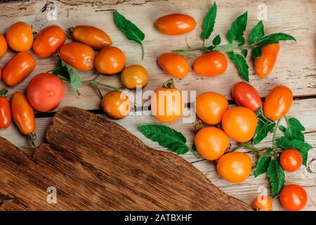 Diversi tipi di pomodori mix. Pomodori gialli colorati di diverse dimensioni Foto Stock