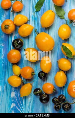 Diversi tipi di pomodori mix. Pomodori gialli colorati di diverse dimensioni Foto Stock