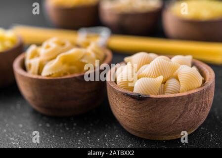 Primo piano di diversi tipi di pasta secca su sfondo nero. Foto Stock