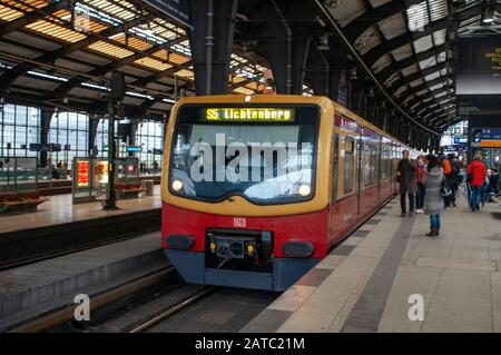 Treno e passeggeri su piattaforme alla stazione ferroviaria di Friedrichstrasse sulla S-Bahn di Berlino Germania Foto Stock