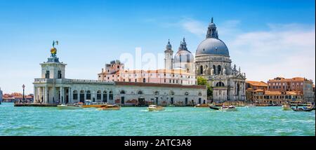 Vista panoramica sul Canal Grande con taxi d'acqua e la chiesa di Santa Maria della Salute a Venezia. Le barche a motore sono il principale mezzo di trasporto a Venezia. Foto Stock