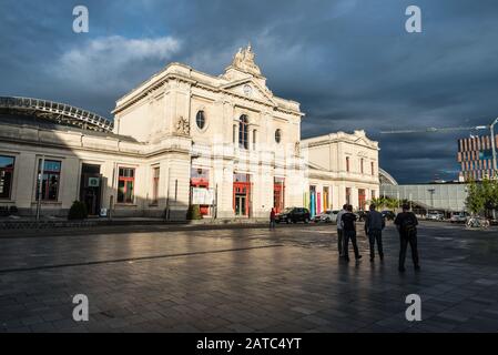 Leuven, Fiandre / Belgio - 06 16 2019: Un uomo che cammina sopra la piazza Martelenplein intorno alla stazione ferroviaria con nuvole tempestose nella ba Foto Stock