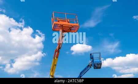 Picker ciliegio su sfondo blu cielo. Braccio con benne per sollevamento di macchinari pesanti. Piattaforme della costruzione telescopica ascensori in estate. Foto Stock