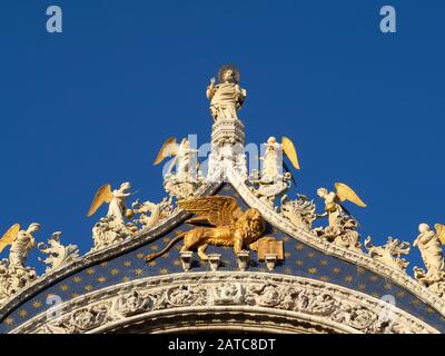 Statua di San Marcos sopra il leone alato di Venezia sulla facciata della Basilica di San Marco, Venezia Foto Stock