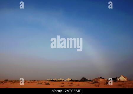 Il fogbow curva sul cielo sopra il campo tenda e dune di sabbia nel Sahara Foto Stock