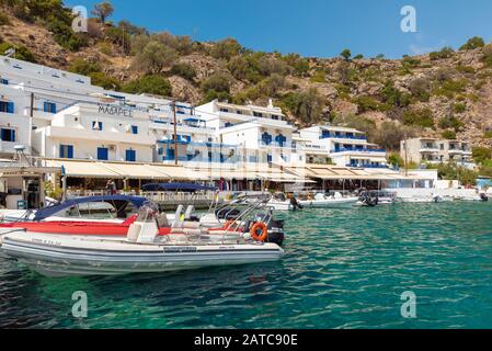 LOUTRO, GRECIA - AGOSTO 2019: Bellissima città con piccolo porto e barche ormeggiate vicino al molo nella parte meridionale dell'isola di Creta Foto Stock