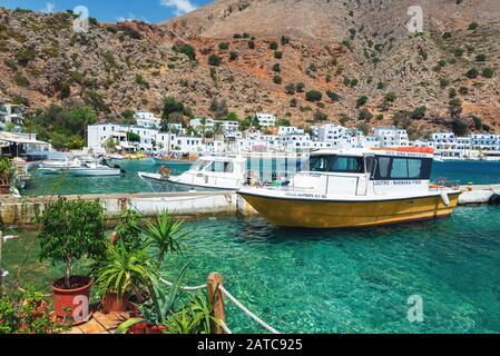 LOUTRO, GRECIA - AGOSTO 2019: Bellissima città con piccolo porto e barche ormeggiate vicino al molo nella parte meridionale dell'isola di Creta Foto Stock