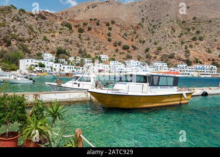 LOUTRO, GRECIA - AGOSTO 2019: Bellissima città con piccolo porto e barche ormeggiate vicino al molo nella parte meridionale dell'isola di Creta Foto Stock