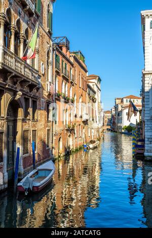 La vecchia strada stretta con una barca a Venezia, Italia. La tradizionale strada veneziana è un canale d'acqua. Le barche sono il trasporto principale a Venezia. Foto Stock