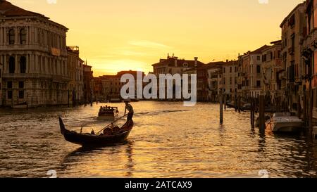 Canal Grande con gondola e barche a motore al tramonto a Venezia, Italia. Il Canal Grande e' uno dei principali corridoi di traffico acquatico e attrazioni turistiche in Foto Stock