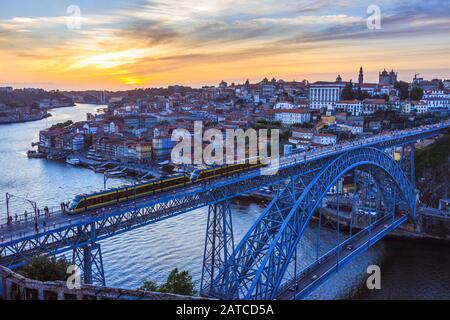 Porto, Portogallo : una corsa in treno al tramonto sul ponte Dom Luis i sul fiume Douro che collega Porto e Vila Nova de Gaia, costruito tra il 1881 e 188 Foto Stock